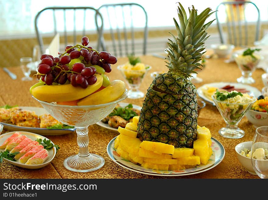 Pineapple, ripe bananas and other fruits and salads on holiday serve table. Pineapple, ripe bananas and other fruits and salads on holiday serve table.