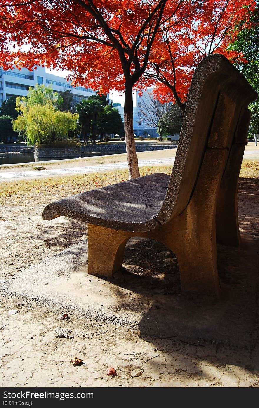 The Stone Chair In The Red Maple Leaf