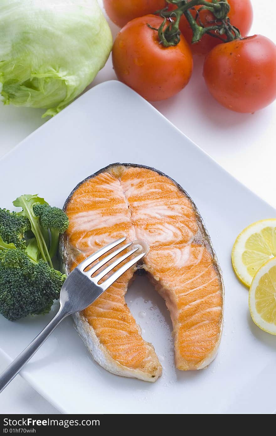 Fresh salmon cooked with tomato salad broccoli salad. Fresh salmon cooked with tomato salad broccoli salad