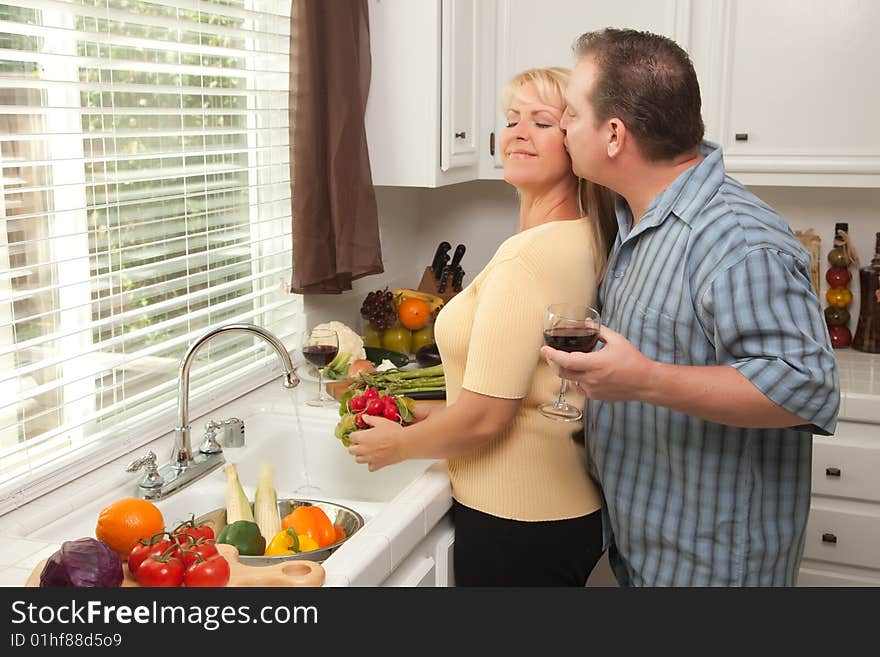 Happy Couple Enjoying An Eveing Preparing Food in the Kitchen.