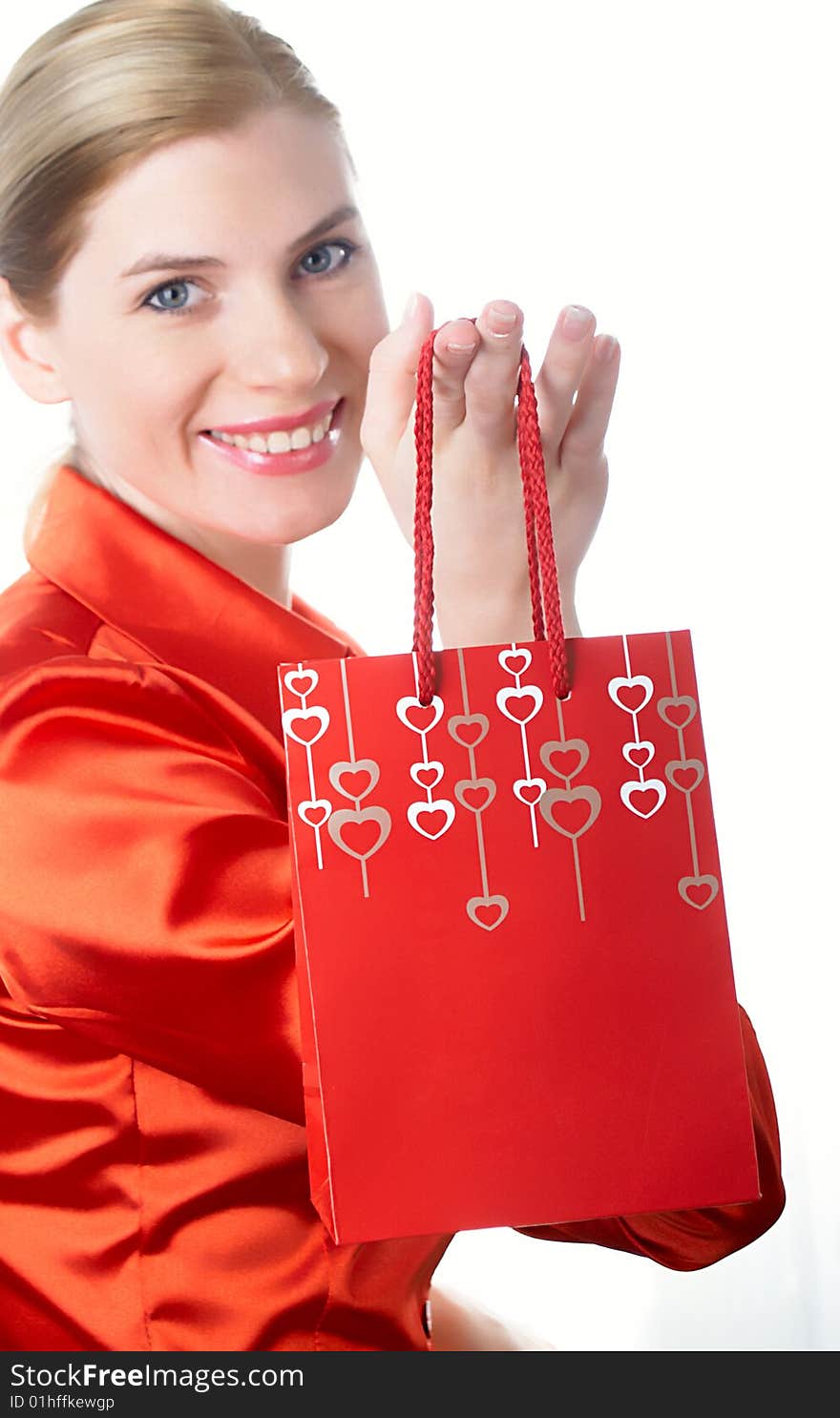 The beautiful girl in red with a gift package in hands