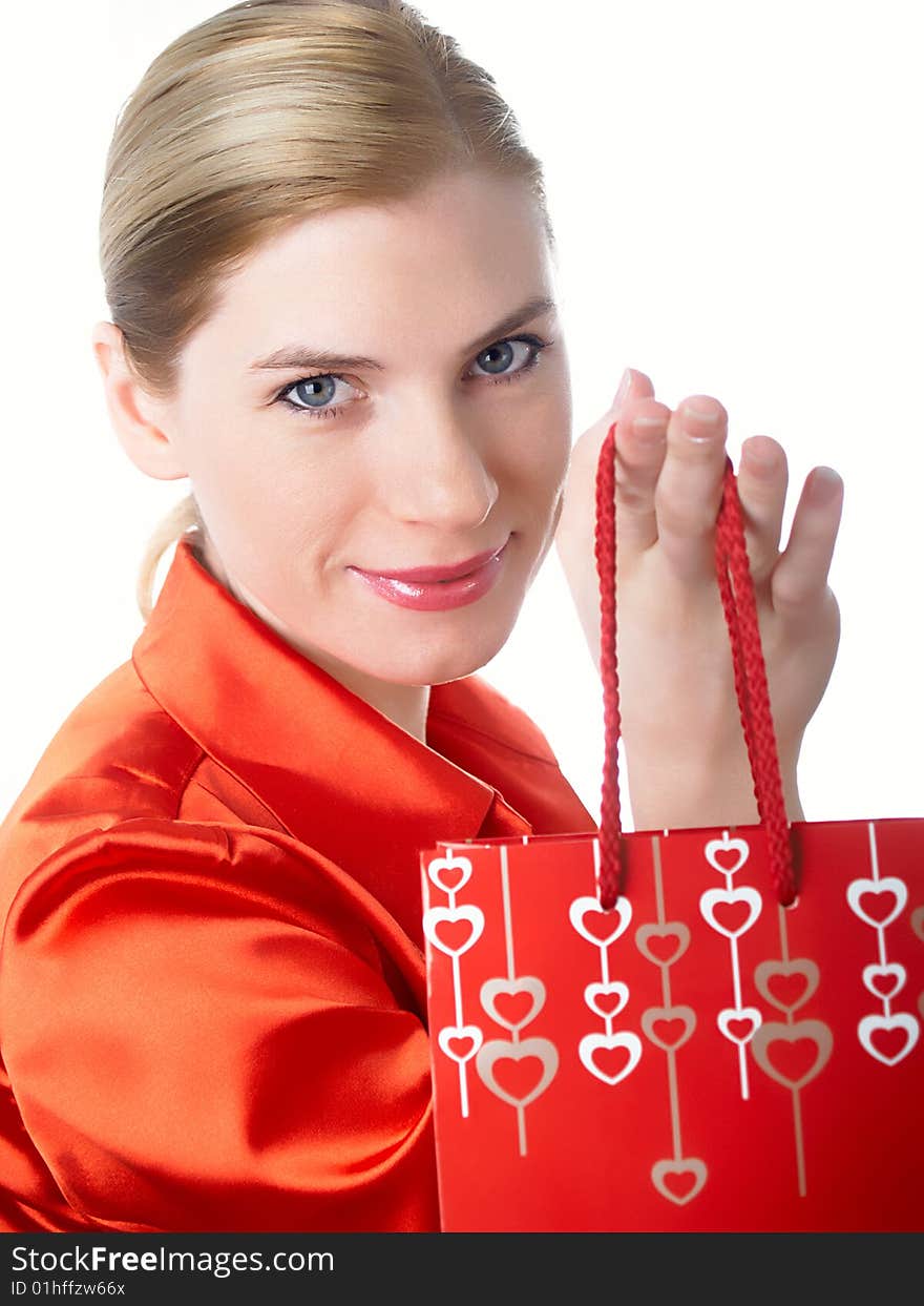 The beautiful girl in red with a gift package in hands