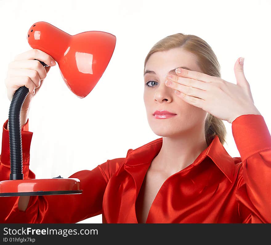 The beautiful girl in red holds a desk lamp in hands