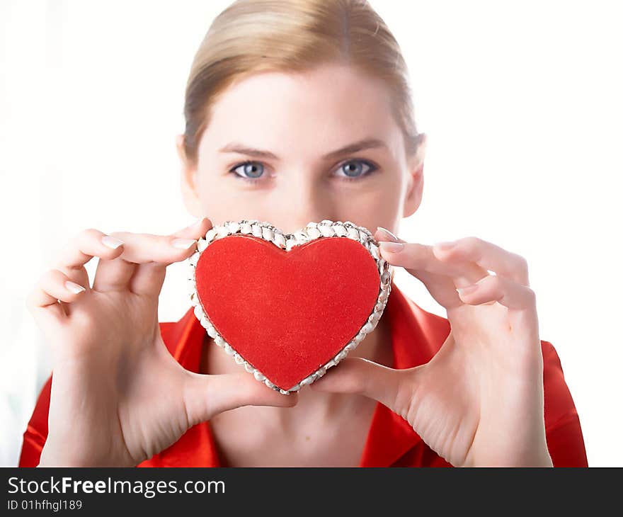 The girl in red holds heart in hands. The girl in red holds heart in hands