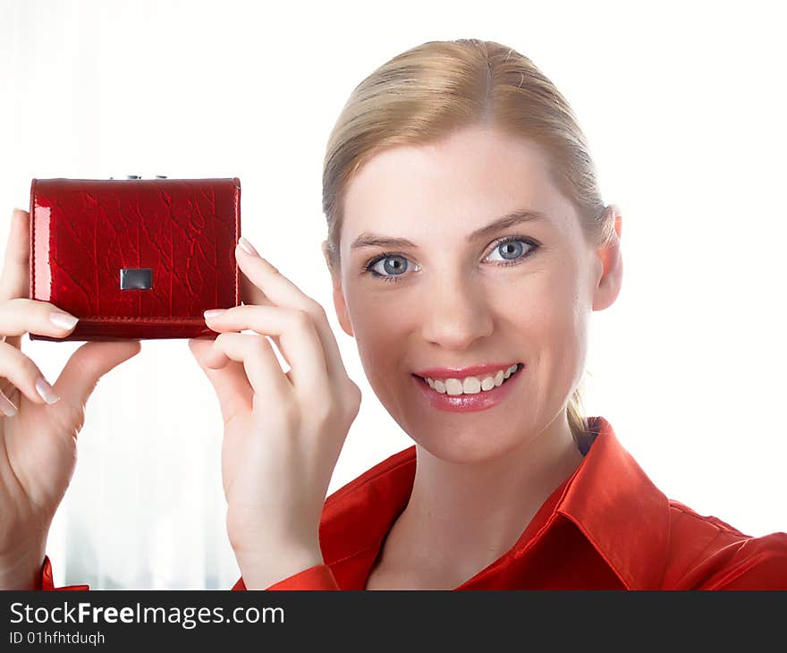 The beautiful girl in red holds in hands a purse for money