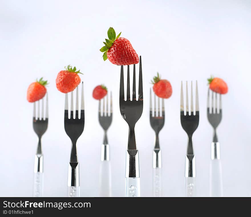 Strawberry with fork isolated on white background