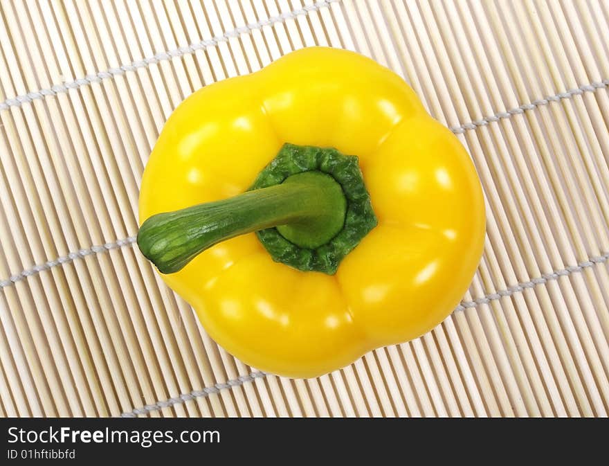 Yellow bell pepper on mat.