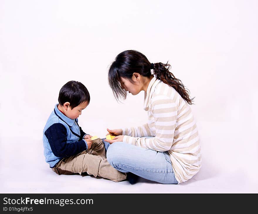 a picture of a little chinese boy playing games with his mother and having great fun. a picture of a little chinese boy playing games with his mother and having great fun