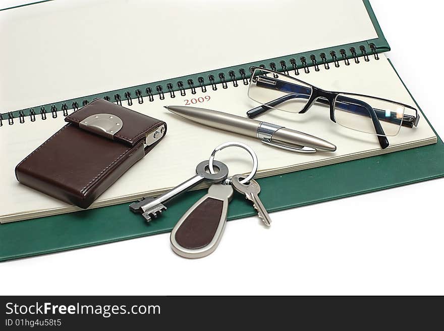 Diary, glasses and keys on a white background