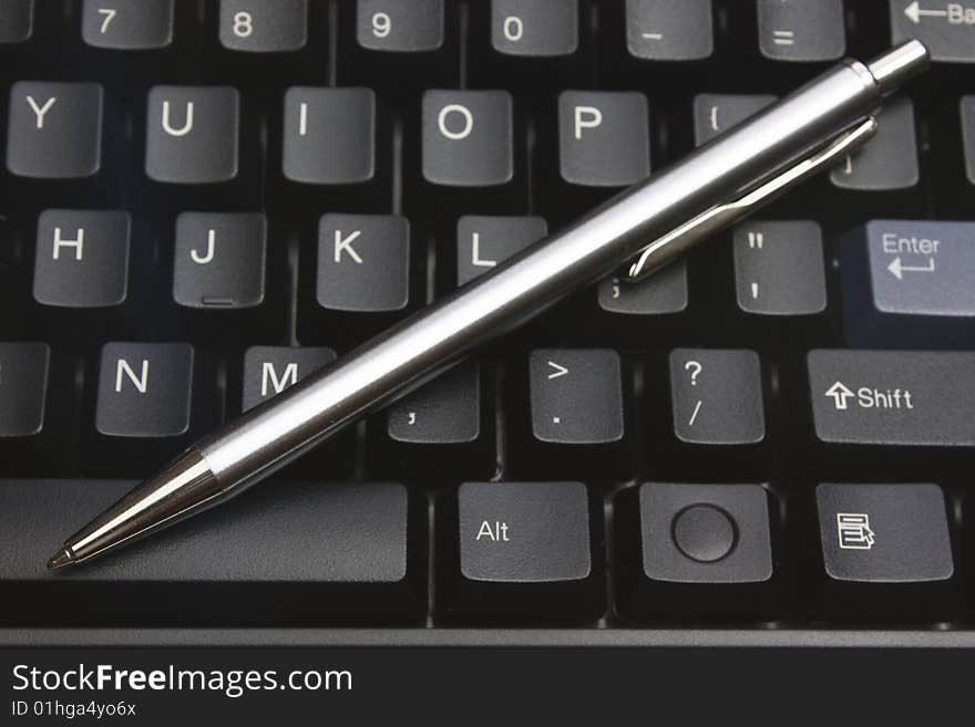 Business metal pen on black keyboard pc. Business metal pen on black keyboard pc