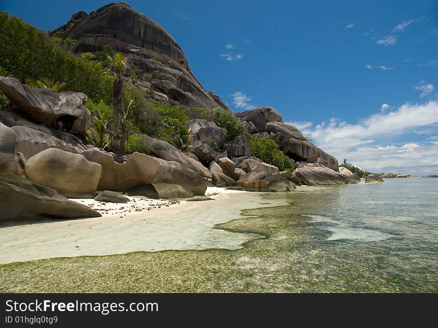 Seychelles stones and palm trees on the bank of azure ocean. Seychelles stones and palm trees on the bank of azure ocean