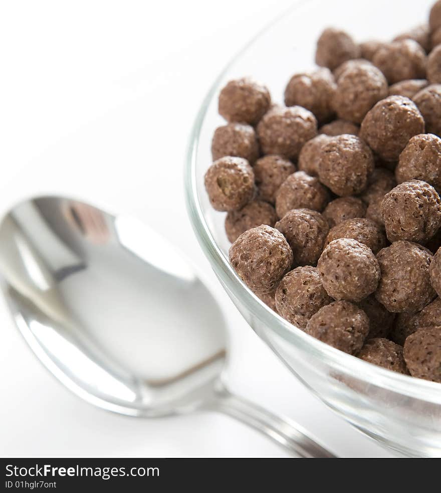 Glass bowl with chocolate balls and chrome spoon