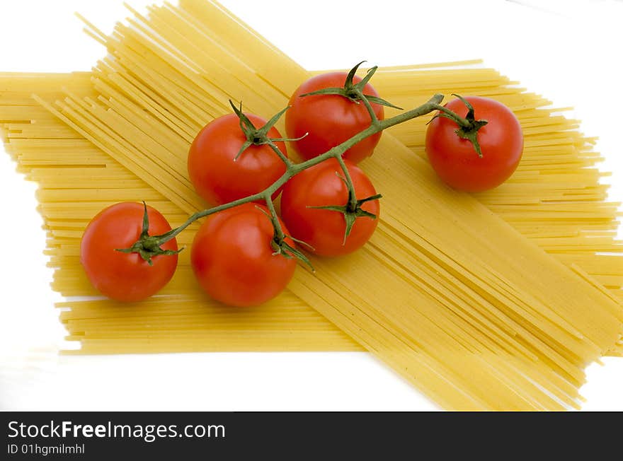 Branch of tomatoes lies on macaroni. Branch of tomatoes lies on macaroni