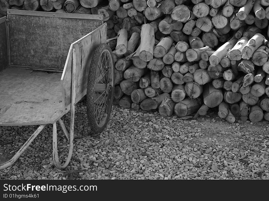 Old cart and stack of firewood on gravel path. Old cart and stack of firewood on gravel path