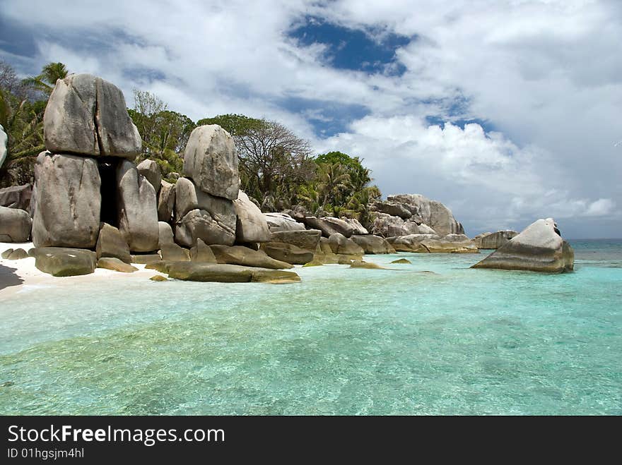 Seychelles stones and palm trees on the bank of azure ocean. Seychelles stones and palm trees on the bank of azure ocean