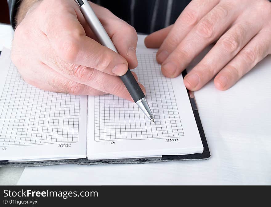 Closeup of mans hand going to write a business plan. Closeup of mans hand going to write a business plan