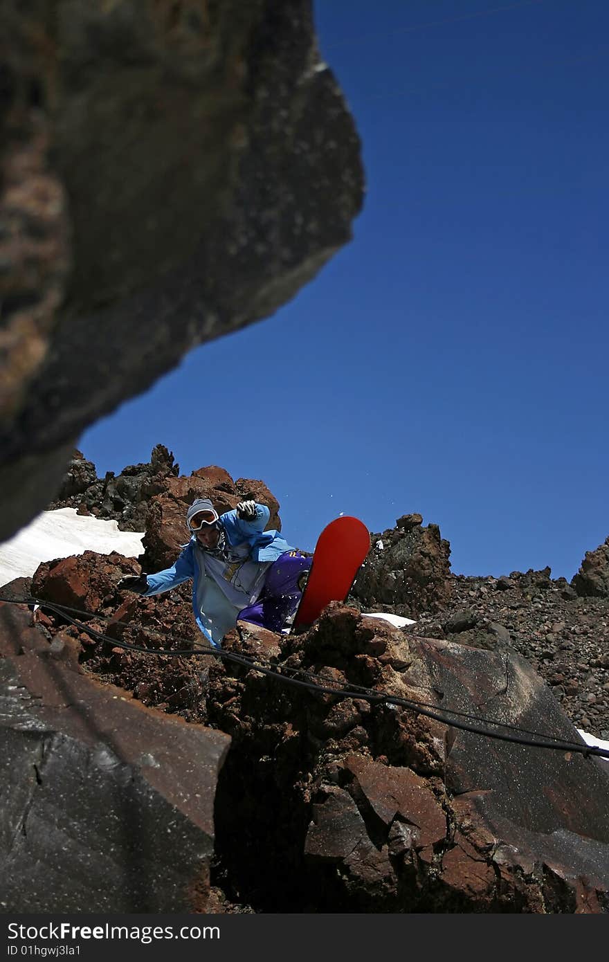 Modern snowboarder riding a rock in mountains. Modern snowboarder riding a rock in mountains