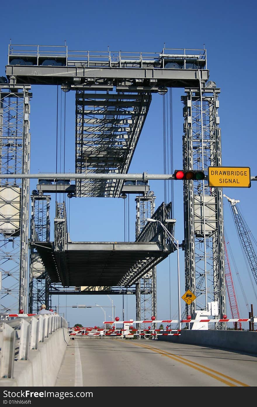 A platform drawbridge about half way up with the lights flashing. A platform drawbridge about half way up with the lights flashing