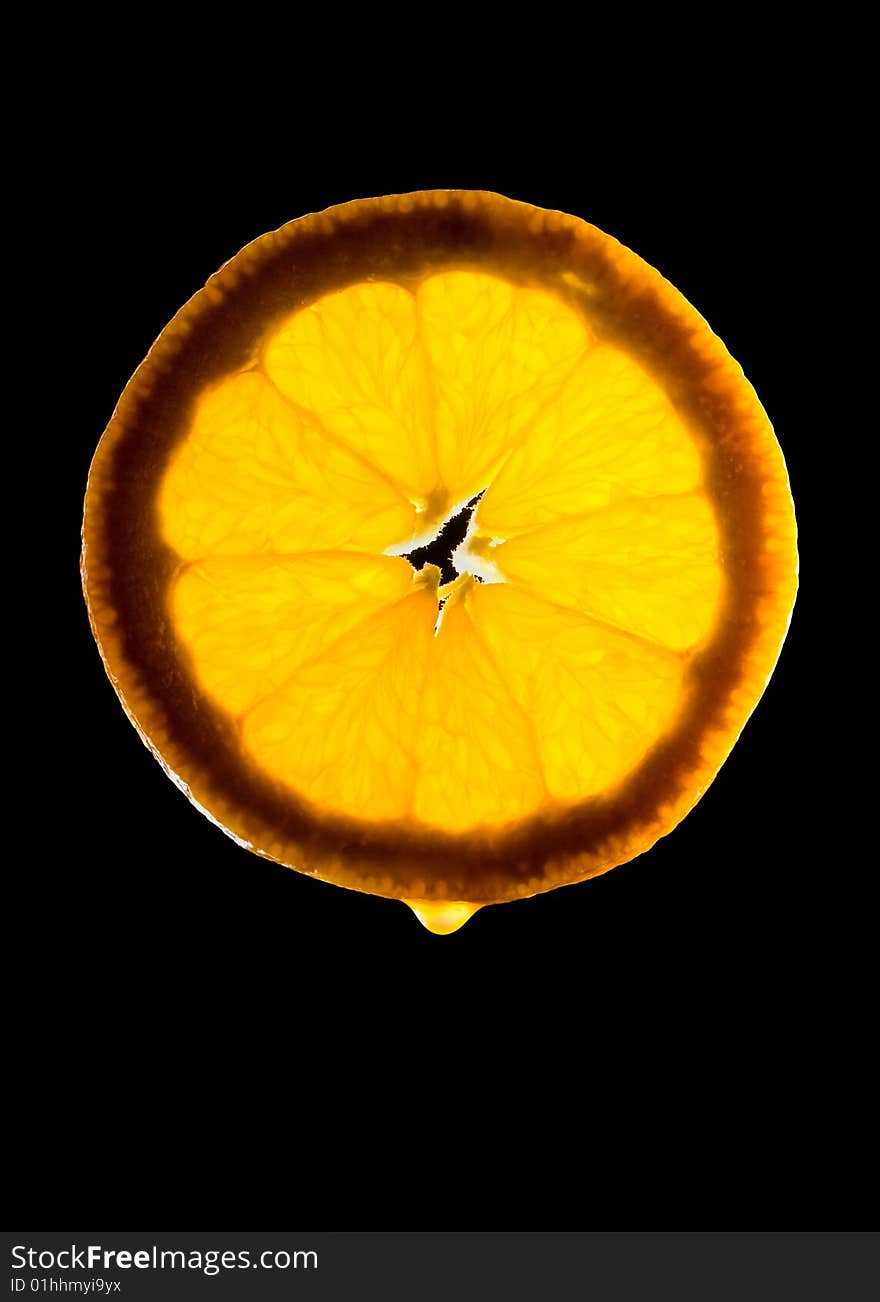 Semi-transparent orange slice with juice drop on black. Semi-transparent orange slice with juice drop on black