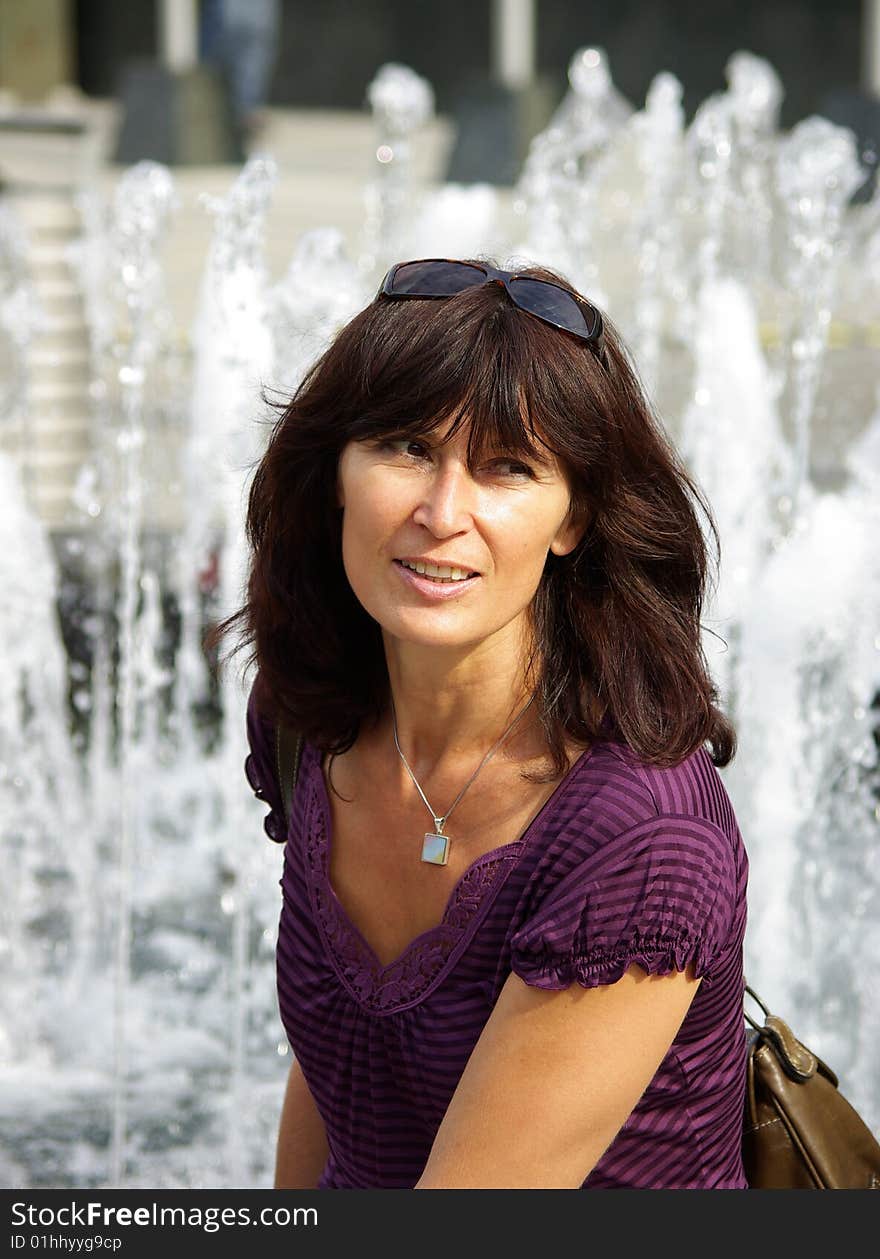 Women sitting alone before fountain. Women sitting alone before fountain