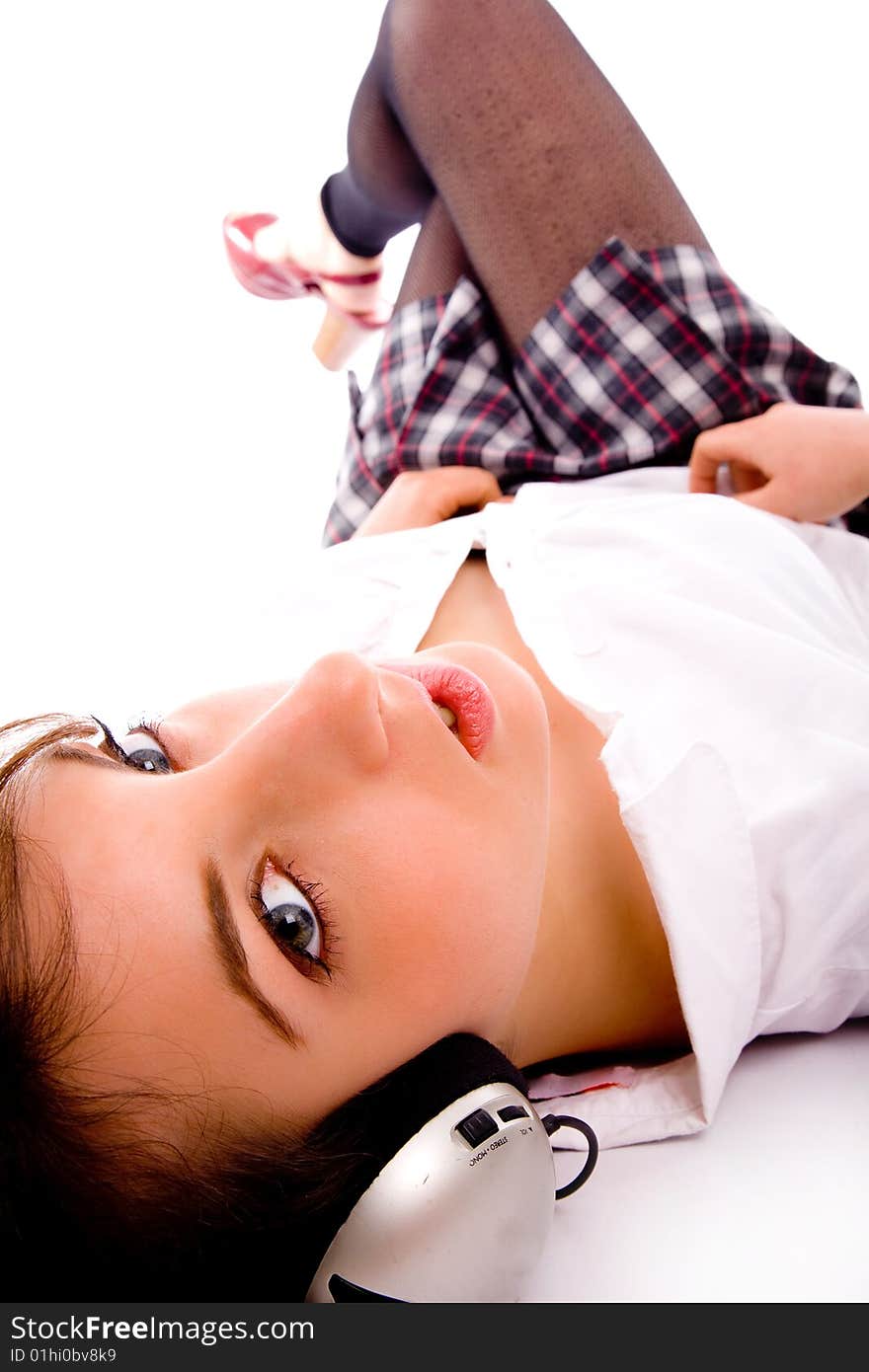 Side pose of female enjoying music with white background