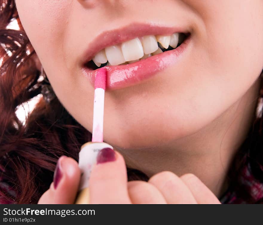 Young woman applying make up, isolated on white background