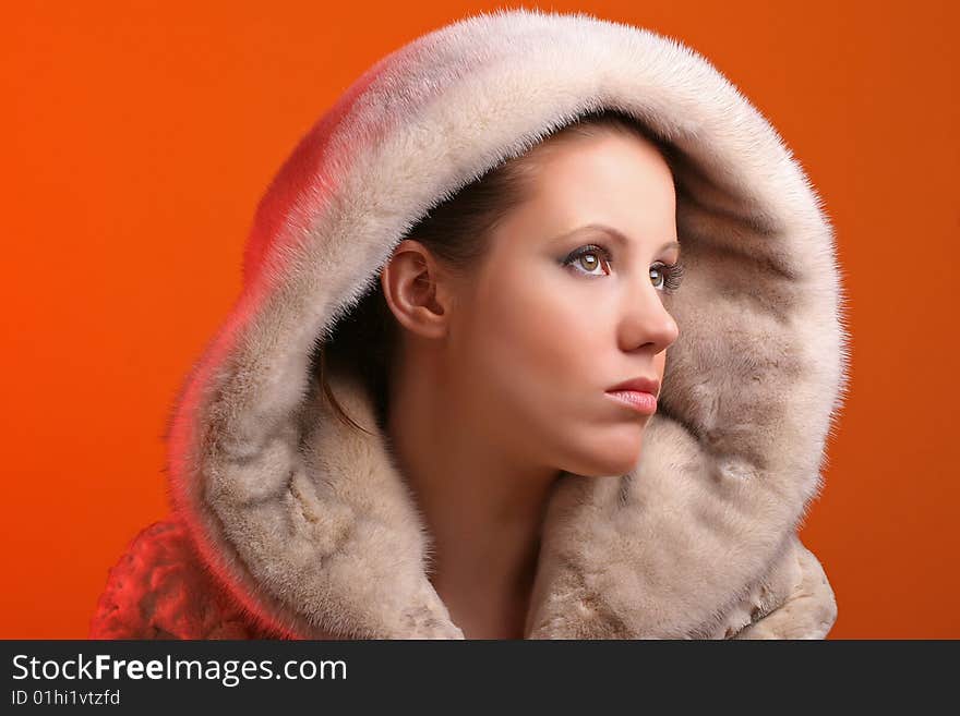 Attractive woman wearing fur isolated on orange background. Attractive woman wearing fur isolated on orange background