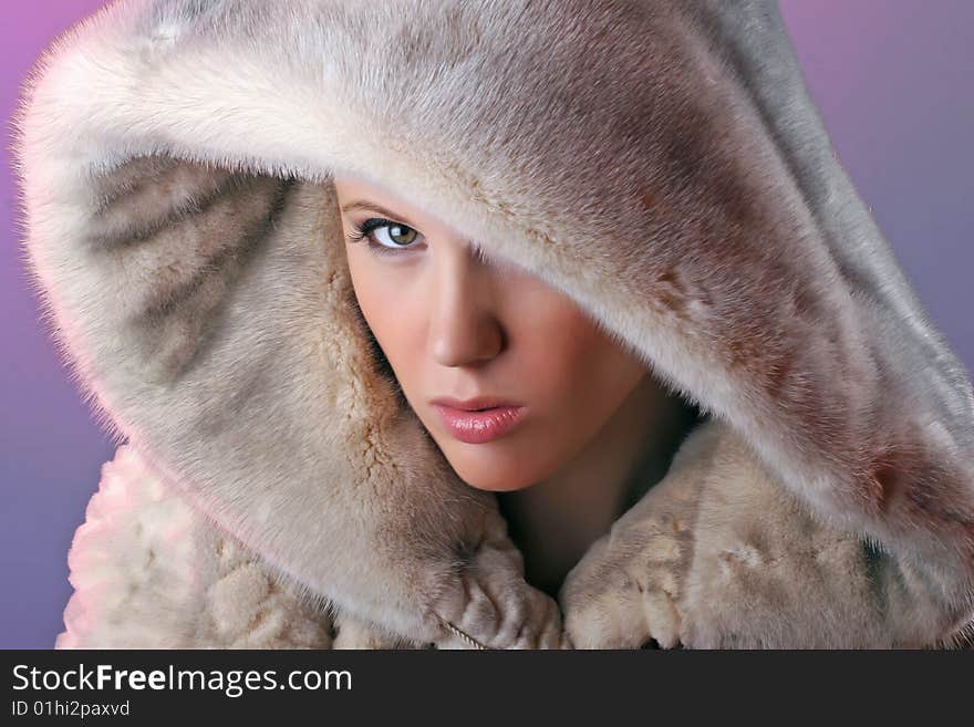 Attractive angry woman wearing fur isolated on blue background. Attractive angry woman wearing fur isolated on blue background