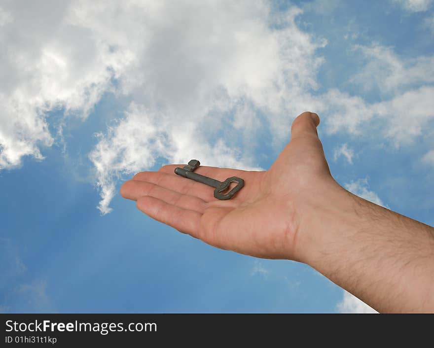 Palm with a key as a gift on sky background