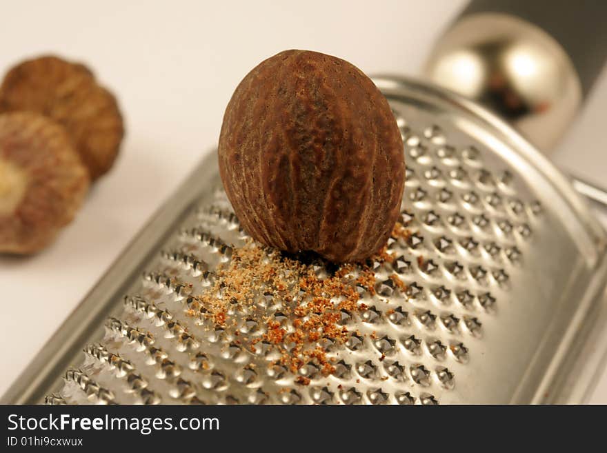 Nutmeg over a metal Grater. Nutmeg over a metal Grater