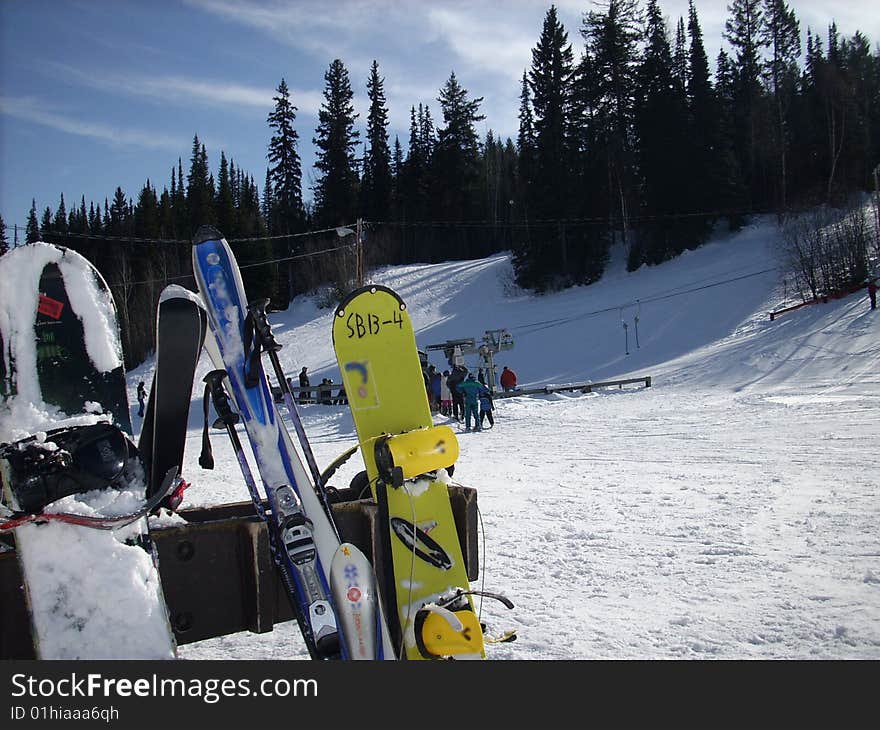 A rack of snow boards waiting for the riders. A rack of snow boards waiting for the riders