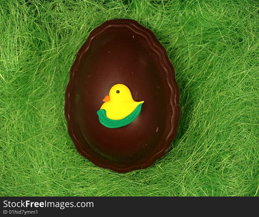 Chocolate decorated egg on the grass background. Chocolate decorated egg on the grass background