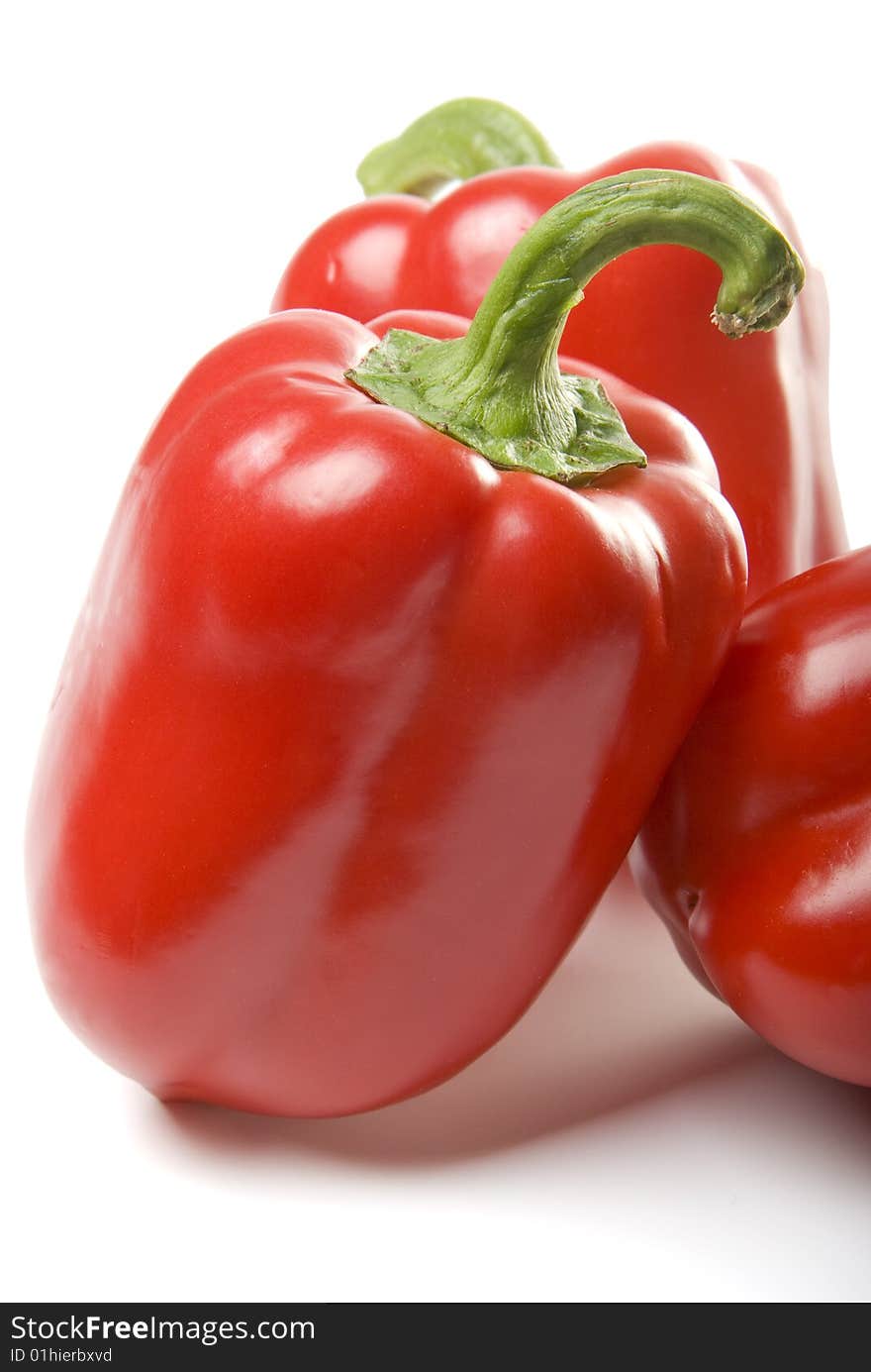 There are a red sweet peppers on the white background. There are a red sweet peppers on the white background