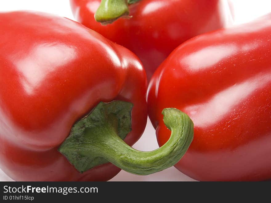 There are a three red sweet peppers on the white background. There are a three red sweet peppers on the white background