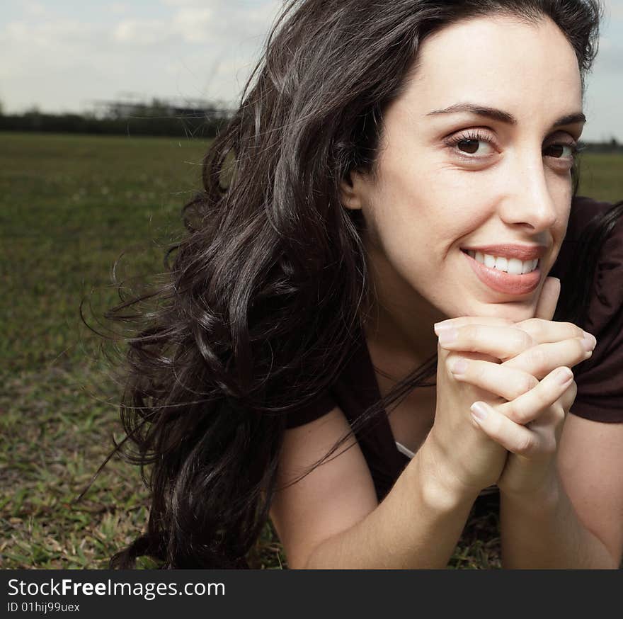 Woman laying on the grass and smiling at the camera. Woman laying on the grass and smiling at the camera