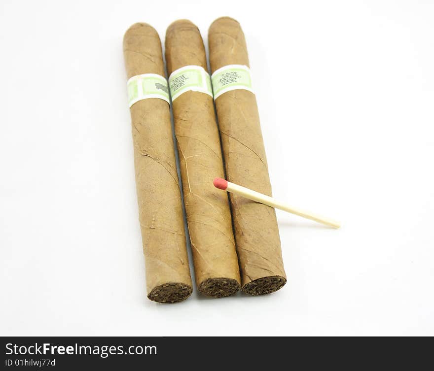 Three cigars and match isolated on a white background.