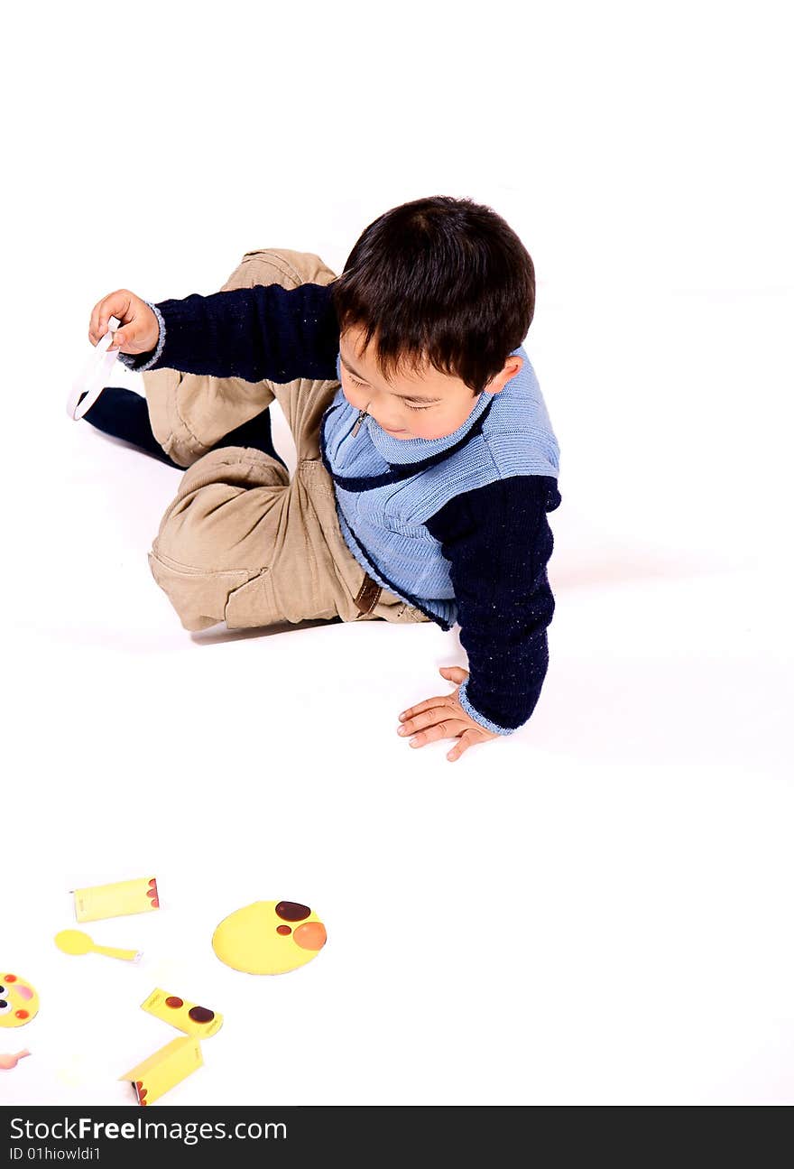 A picture of a little chinese boy piecing picture together and having great fun