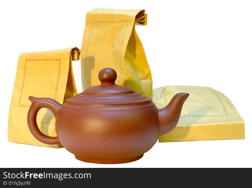 Chinese pottery (clay) teapot and tea in paper bags on isolated background. Chinese pottery (clay) teapot and tea in paper bags on isolated background.