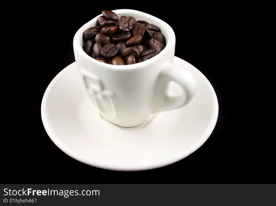 Coffee Cup with coffee beans in it on a Black Background. Coffee Cup with coffee beans in it on a Black Background