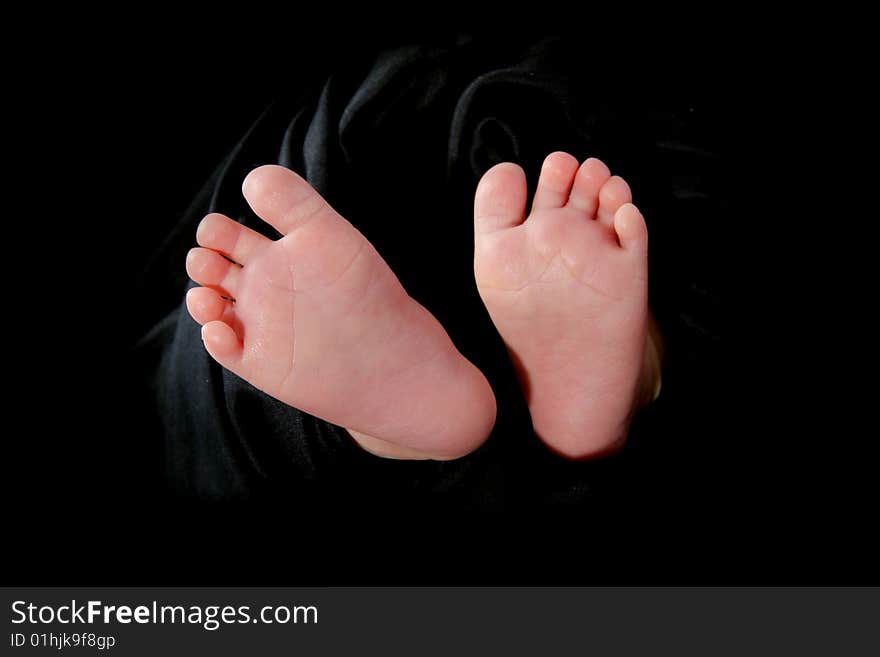 Baby feet in a black  towel