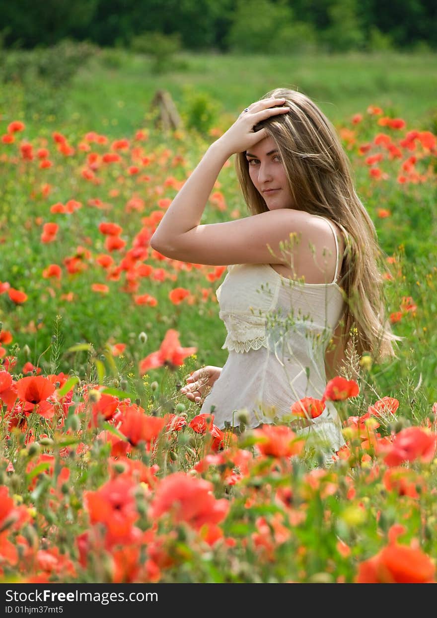 Young girl with long hair in poppies field