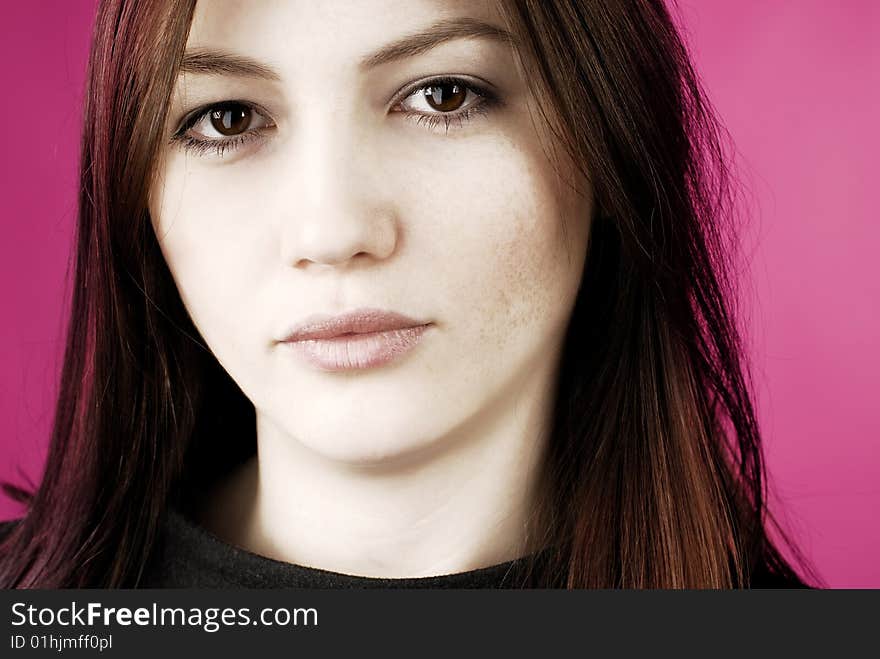 Portrait of a young woman on the pink background with freckles and dry lips. Portrait of a young woman on the pink background with freckles and dry lips