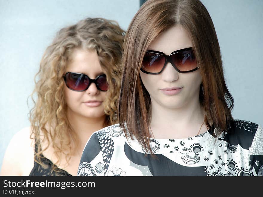 Two girls wearing glasses trying to make some concept like Men in Black