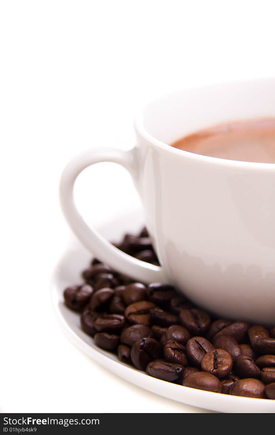 Close-up of a cup of hot coffee and beans