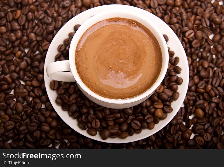 Close-up of a cup of hot coffee and beans