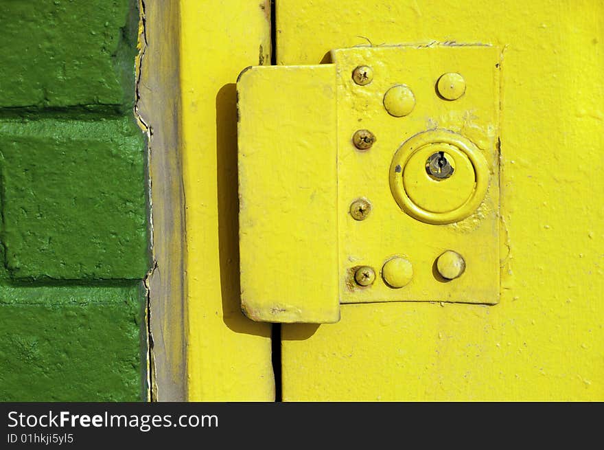 Yellow exterior door lock on an urban building. Yellow exterior door lock on an urban building.