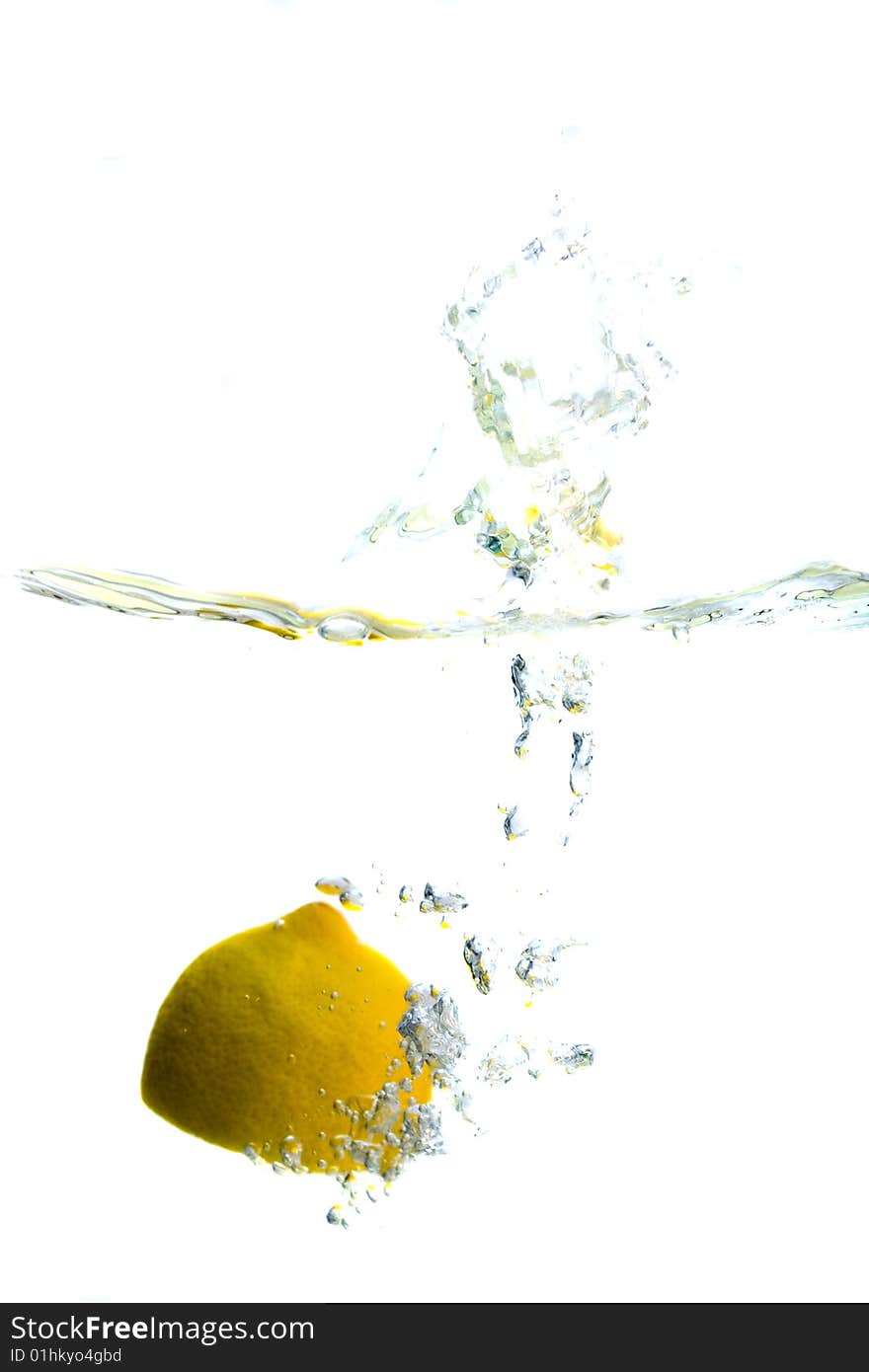 Big yellow lemon splashing in water