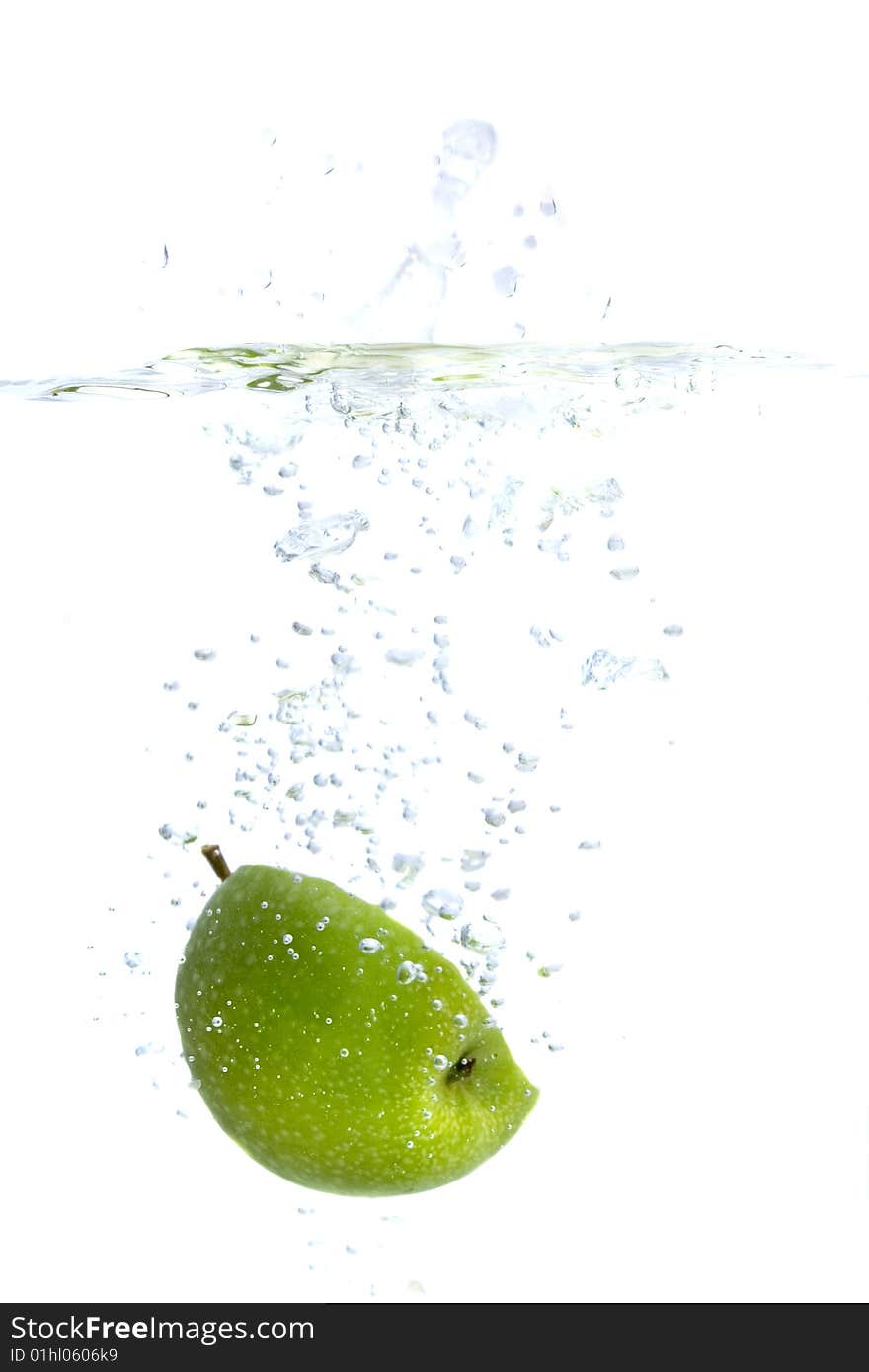 Big green apple splashing in water