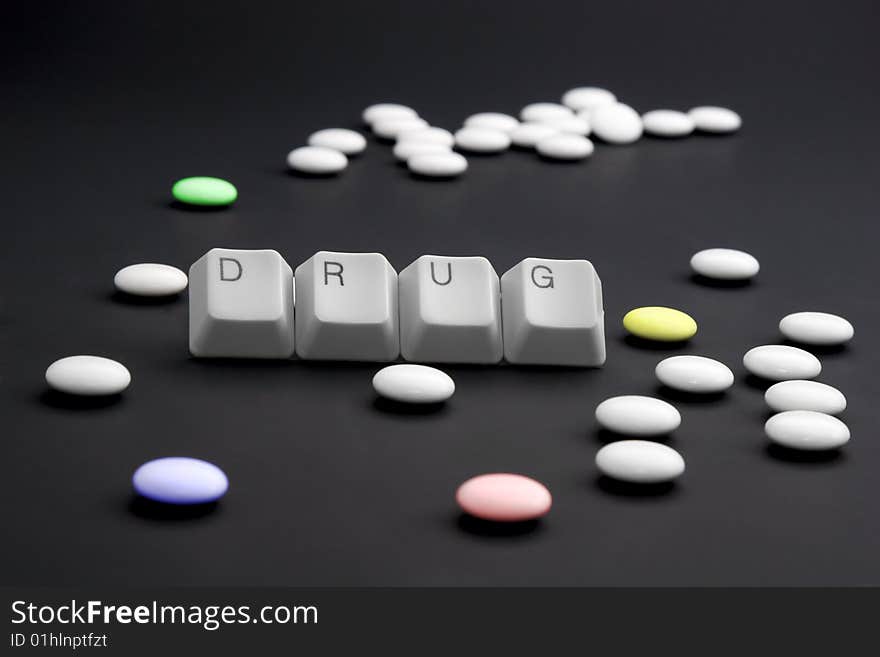 DRUG caption by keyboard keys and pile of pills on black. DRUG caption by keyboard keys and pile of pills on black