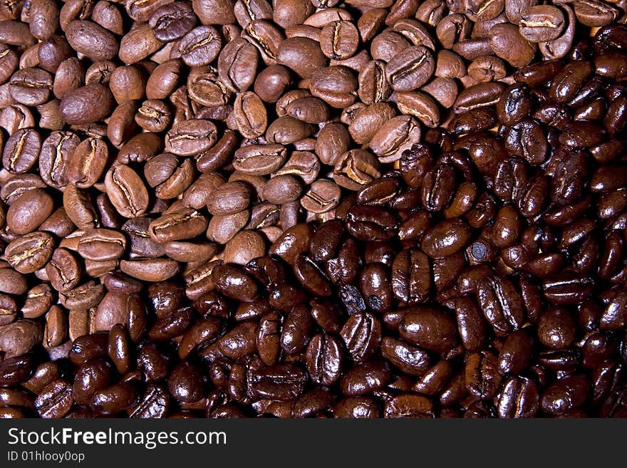 Close-up contrasting background image of dark and medium roast coffee beans. Close-up contrasting background image of dark and medium roast coffee beans.